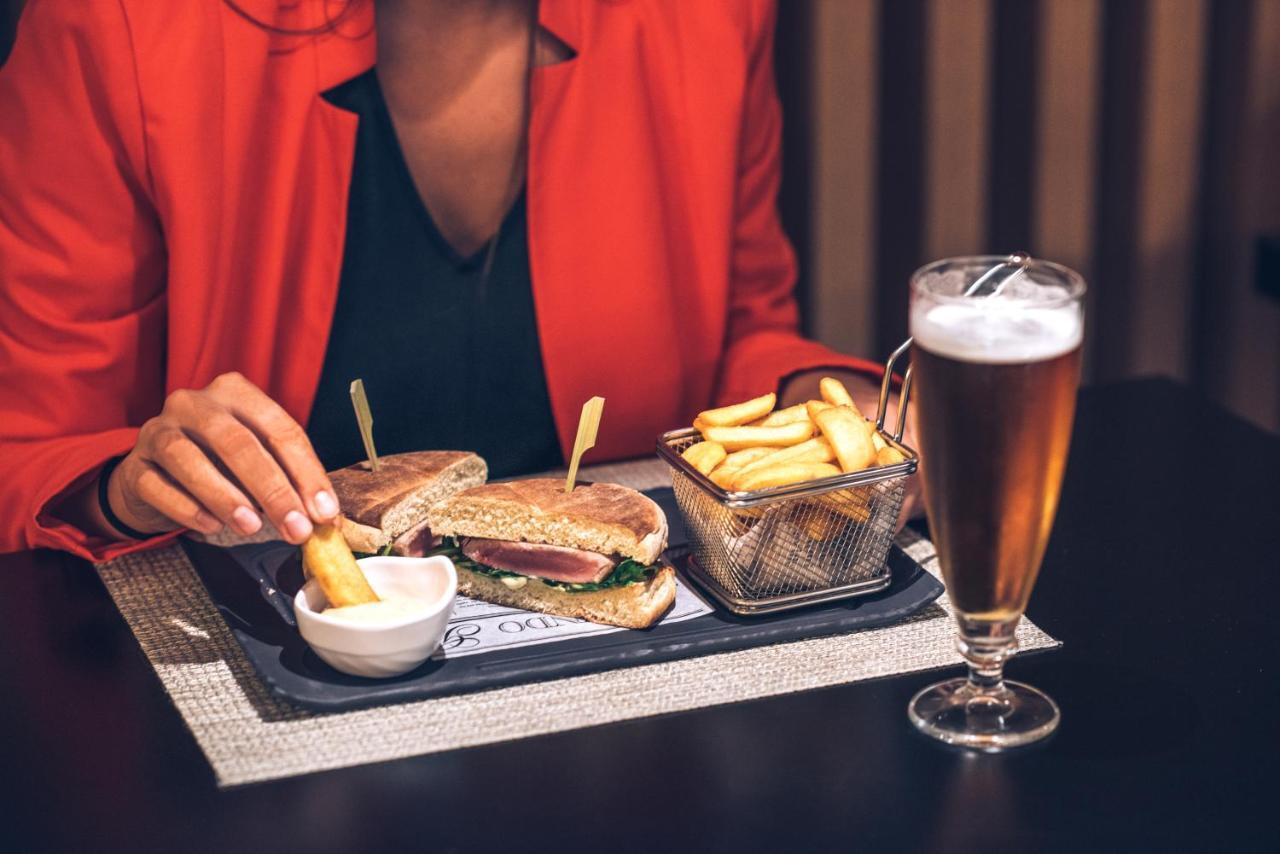이베로스타 셀렉션 리스보아 리스본 외부 사진 A woman eating a hamburger and chips